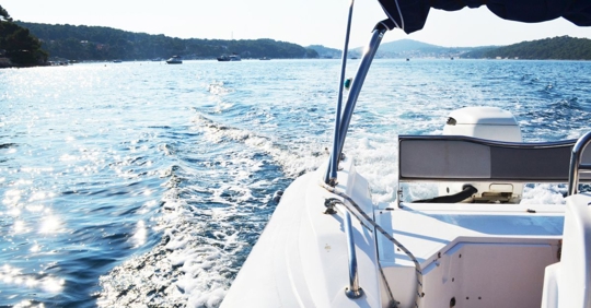View from the back of a speed boat cruising on open water.