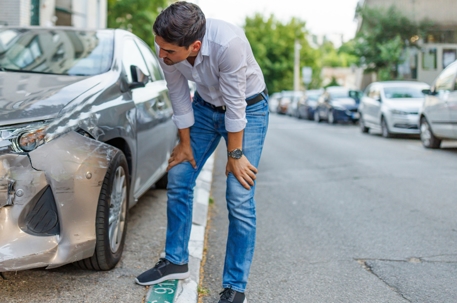 Man looking at his car after an accident