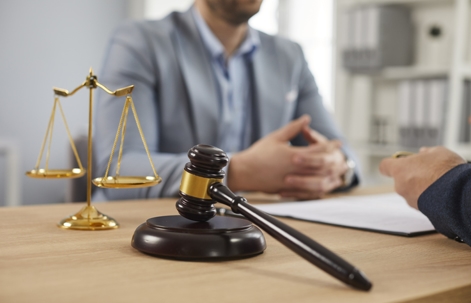 Lawyer and client sitting across from each other with a gavel on the table